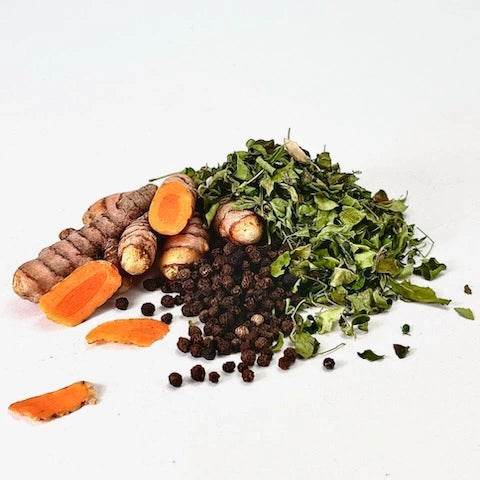 A pile of raw herbs of turmeric, black pepper and moringa