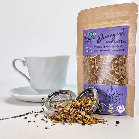 Decongesting loose leaf tea with raw ingredients, tea ball and white tea cup