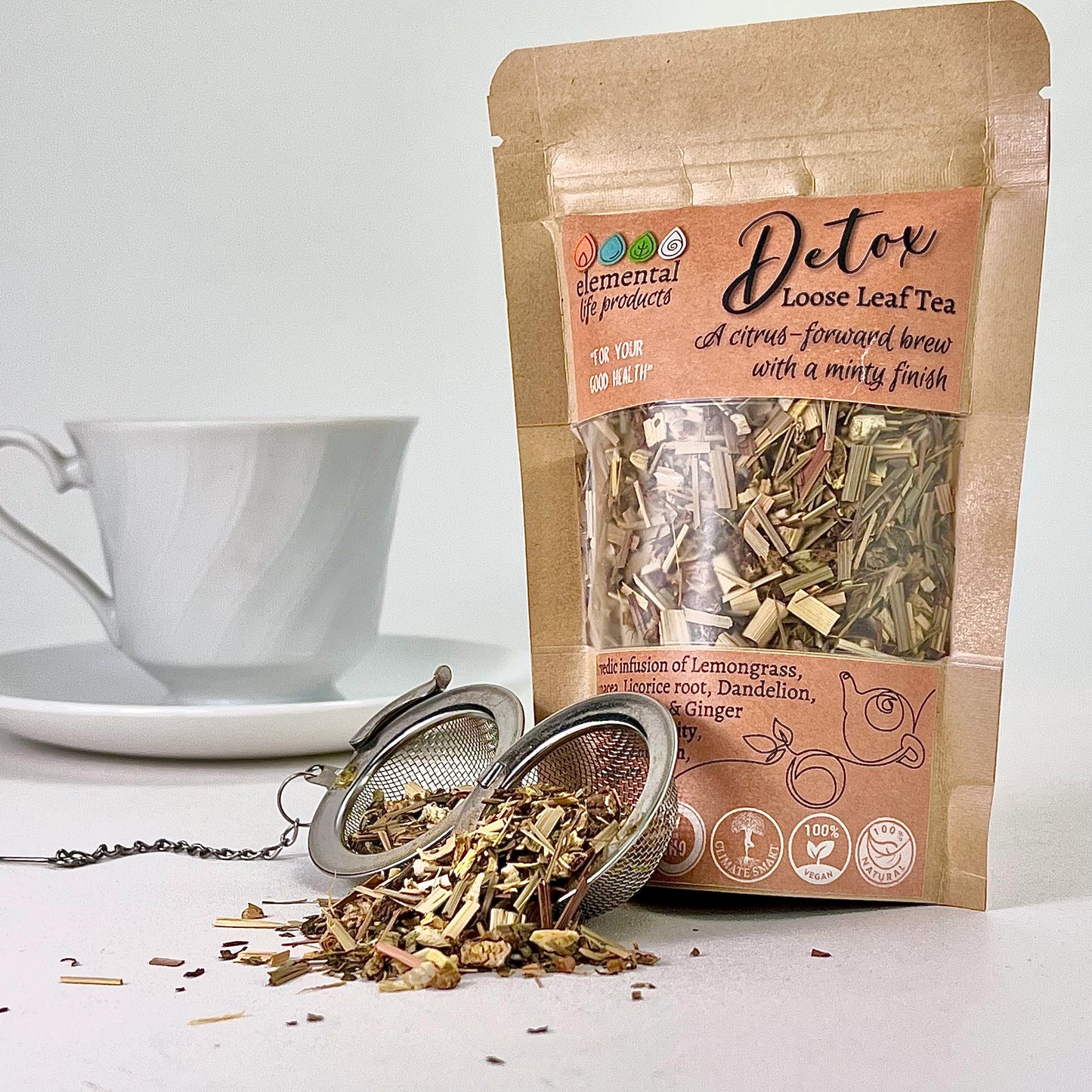 Elemental life product's Detox tea with raw ingredients of Lemongrass, Echinacea, Licorice, dandelion with a tea ball and cup